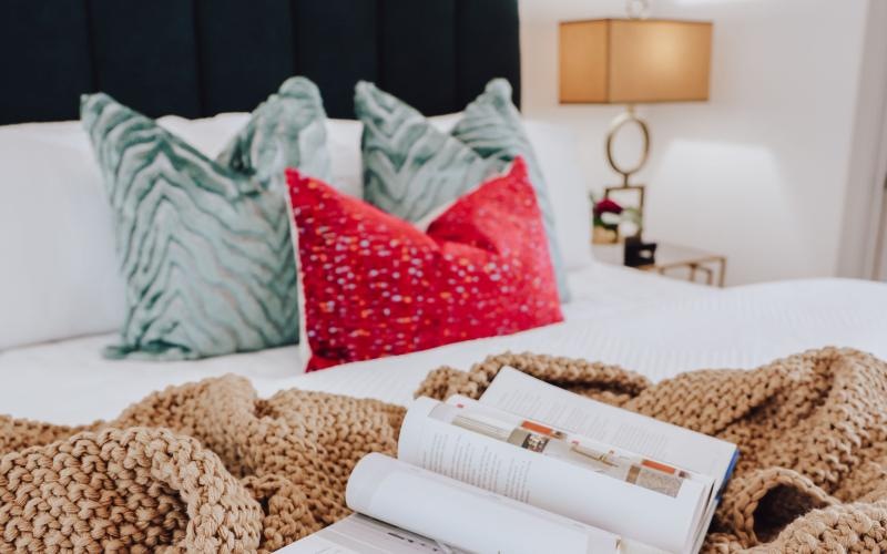 a bed with a book and pillows